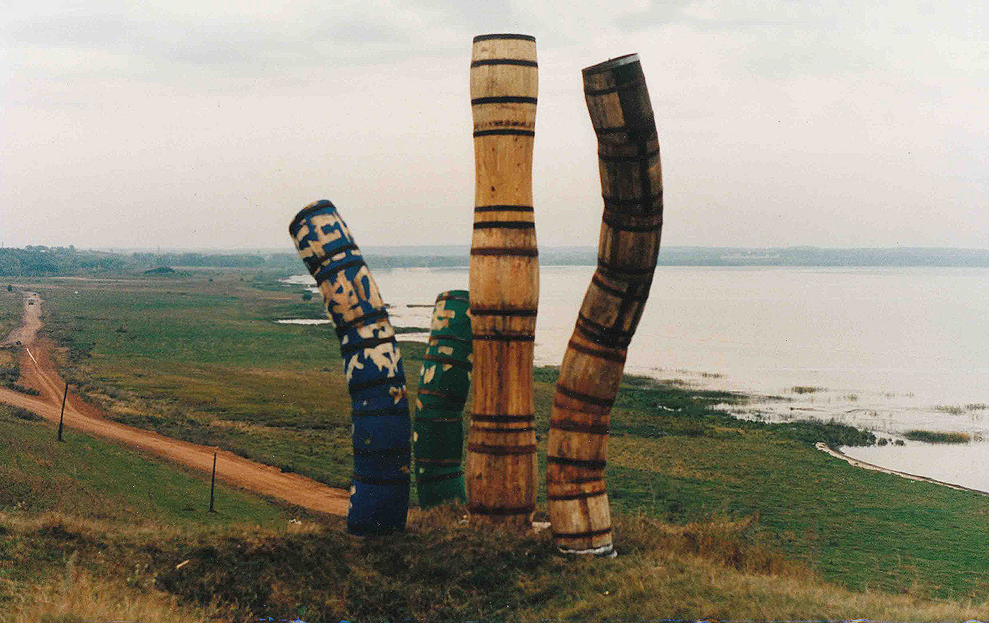 Владимир Говорков. "Вглядываются", 1994. Бочки, дерево, металл, акрил, 390х80 см, 380х129 см, 240х60 см, 230х80 см. Окрестности Плещеева озера, Ярославская область. Фото из архива Владимира Говоркова