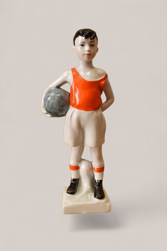 ''Юный футболист'', 1950 - 1960-е.Фарфор, подглазурная и надглазурная роспись, 17х7,5х4 см.Чайковский историко-художественный музей, Пермский край.Фото: goskatalog.ru