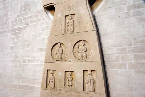 Анатолий Комелин. Белорусские святые. Фрагмент поклонного креста, 2015-2019. Камень. Фасад. Храм иконы Божией Матери ''Млекопитательница'' в Раубичах, Белоруссия. Фото из архива А. Комелина